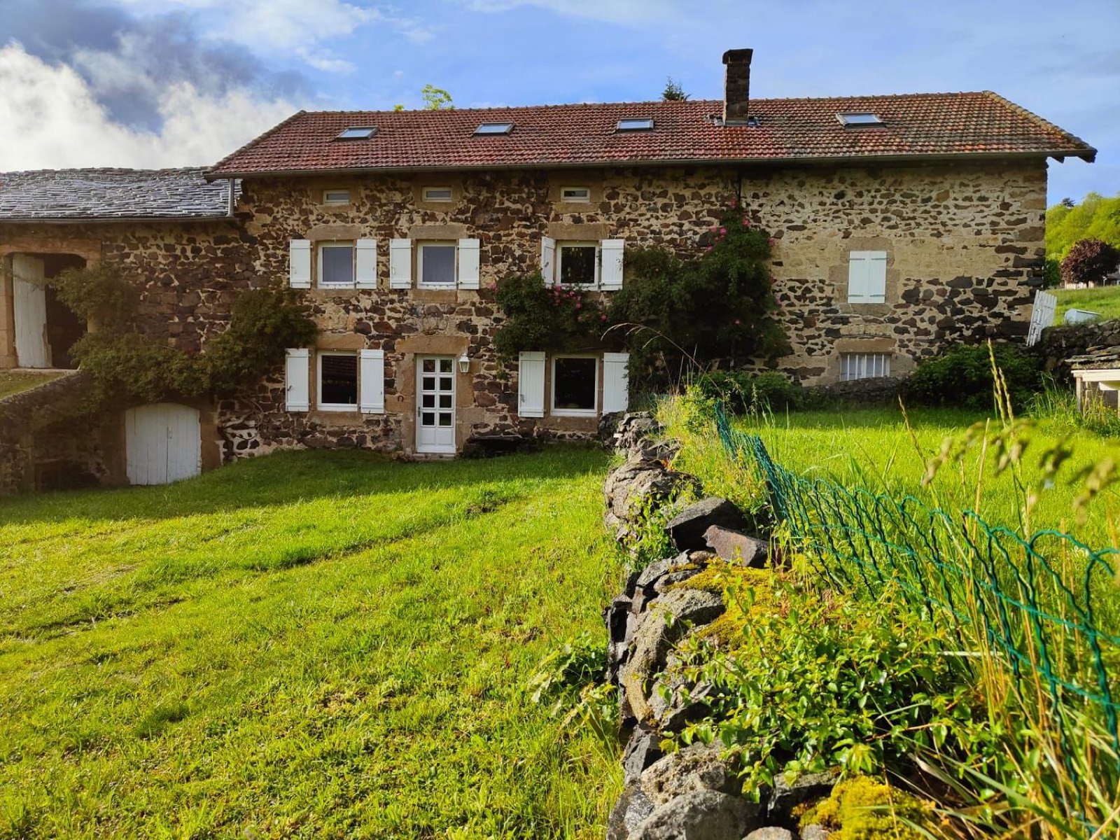 Stone facade of the house with white shutters