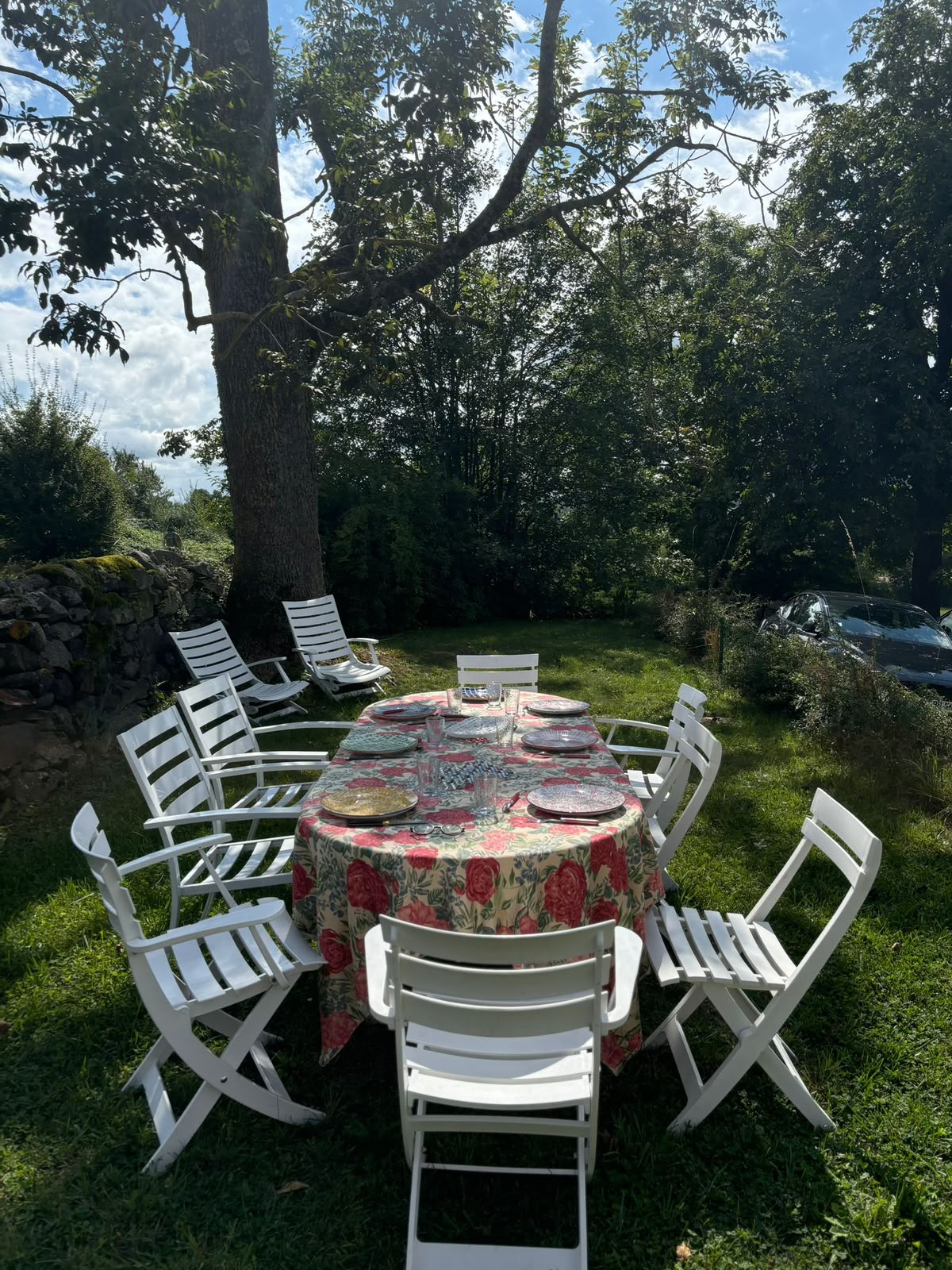 Grande tablée dressée dans le jardin, sous les arbres