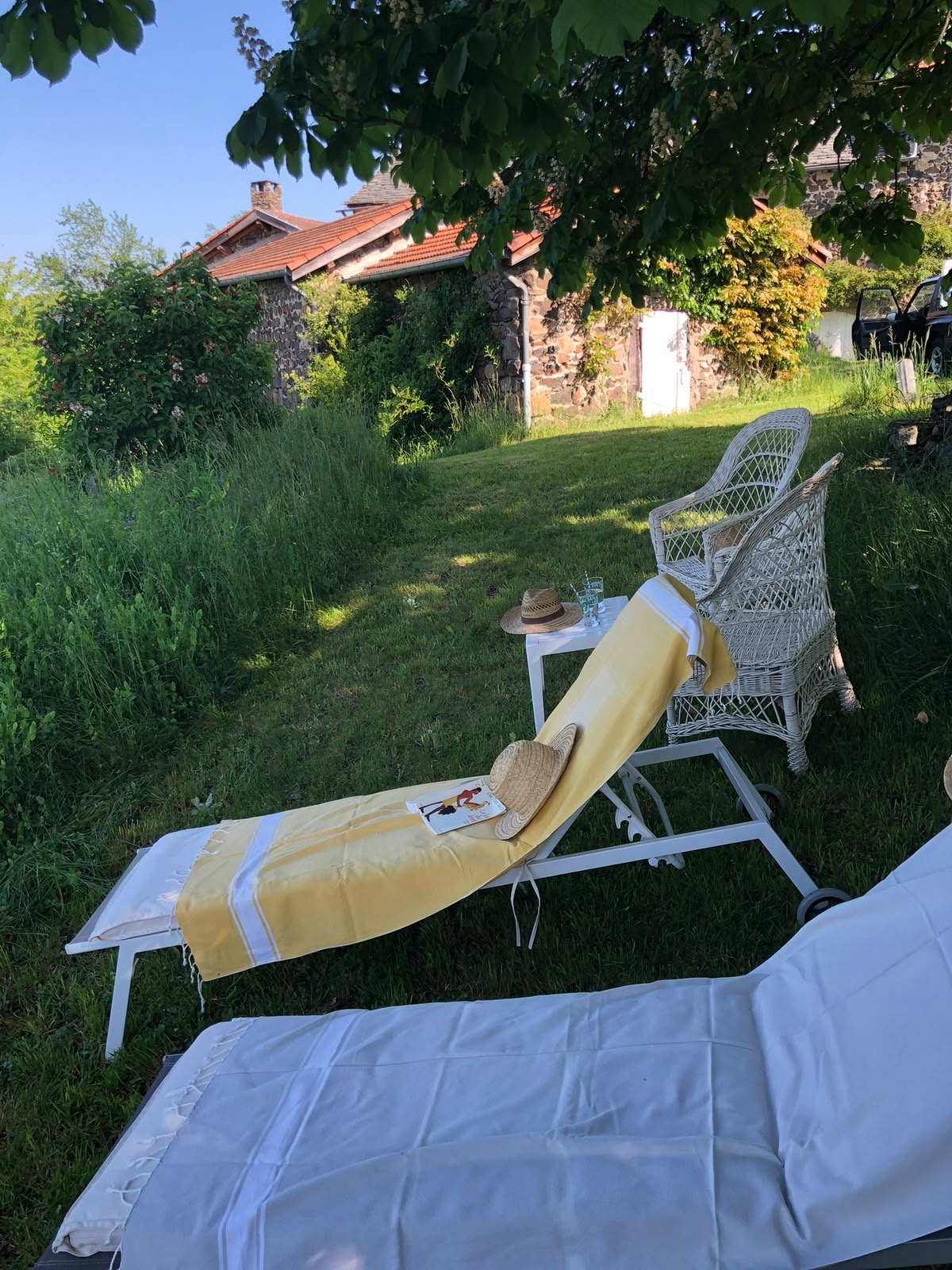 Transats dans le jardin, vue sur la dépendance en pierre